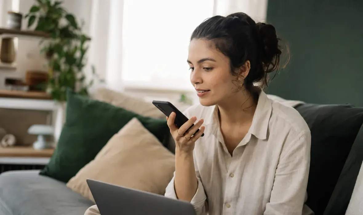 Jovem no sofá de casa pesquisando uma empresa da cidade num assistente de inteligência artificial pelo celular