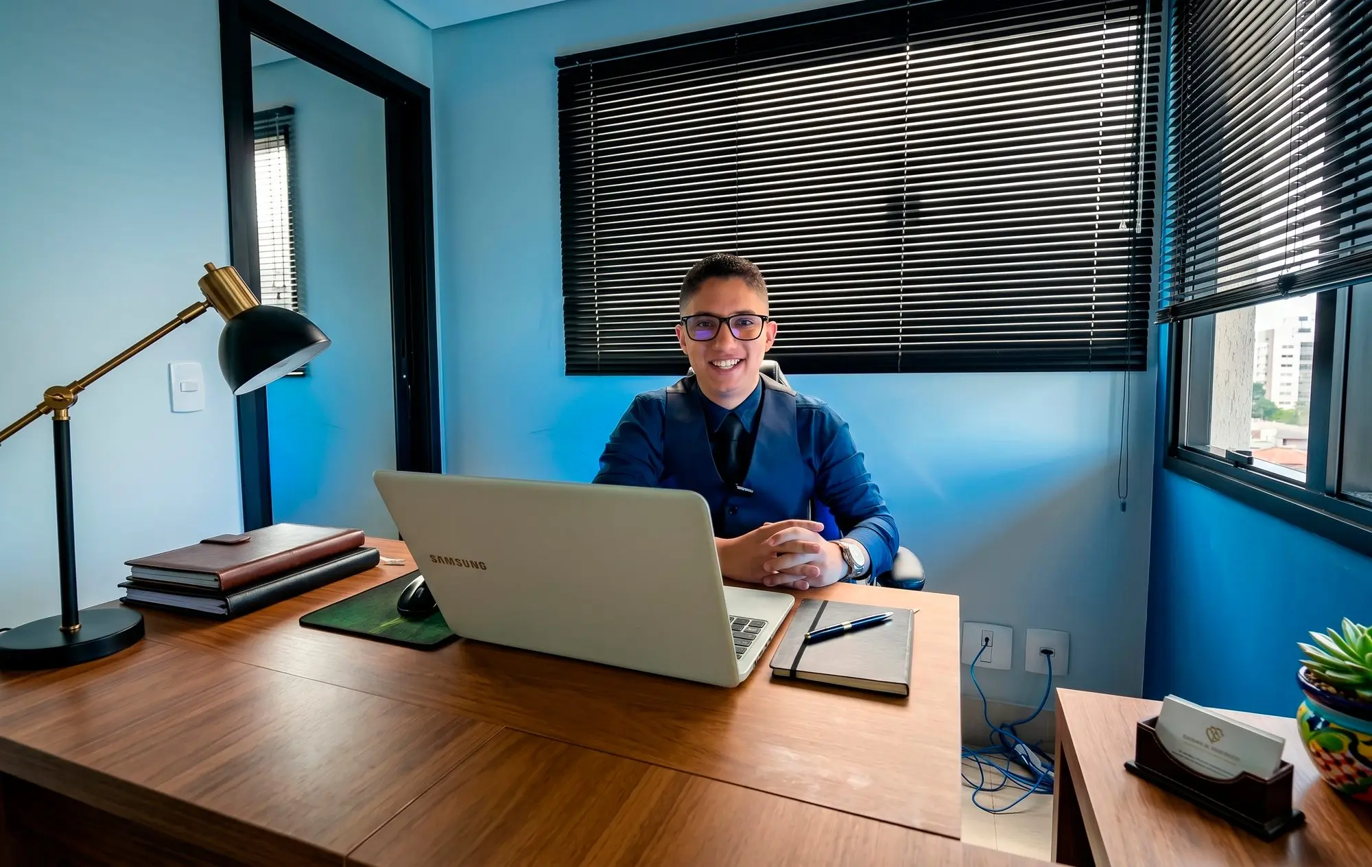 Consultor da Agência EvoluaC sorrindo na mesa de trabalho, pronto para ouvir o caso do cliente