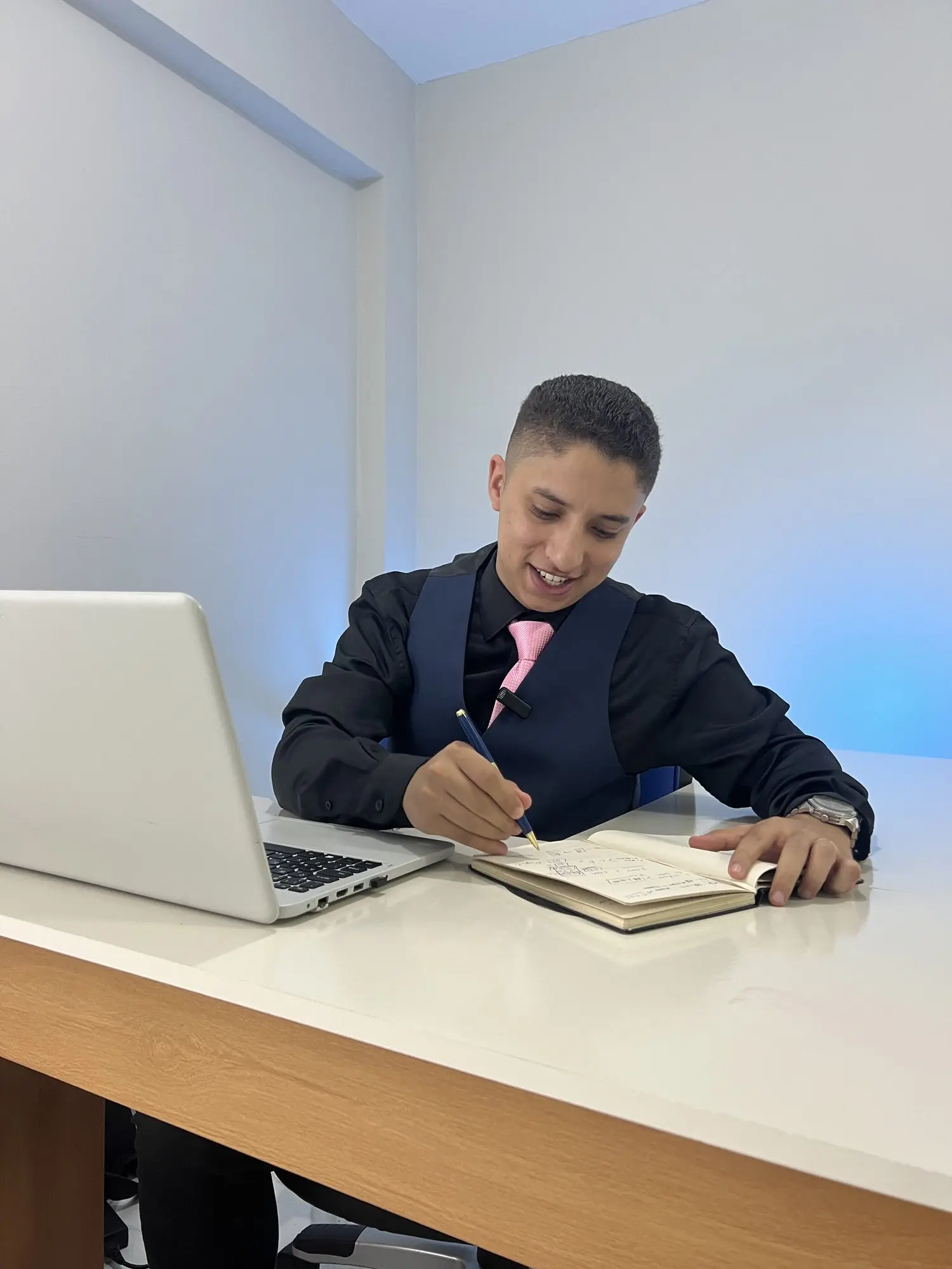 Consultor da Agência EvoluaC anotando o planejamento de um cliente, ao lado do notebook