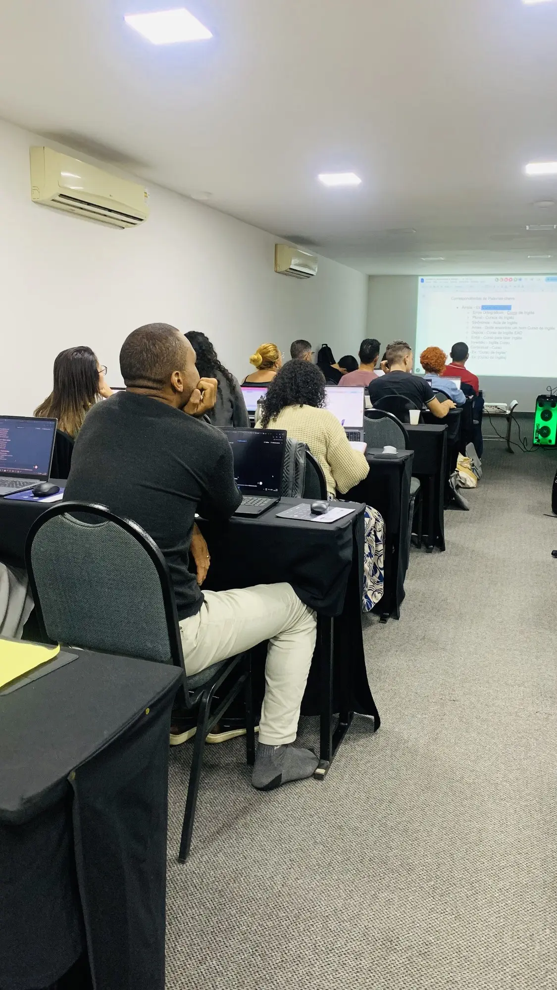 Participantes acompanhando a aula no notebook durante um treinamento da EvoluaC