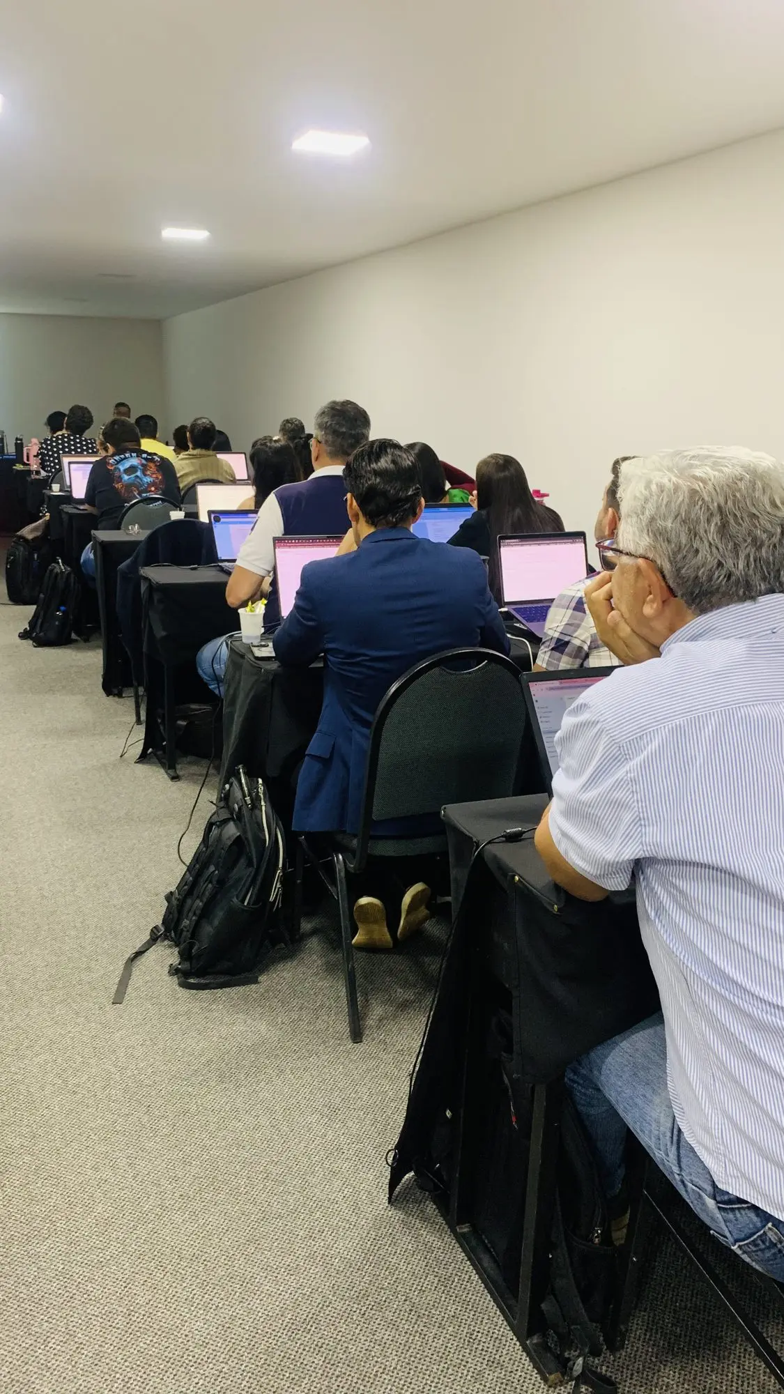Turma de empresários em um treinamento presencial da EvoluaC, em auditório